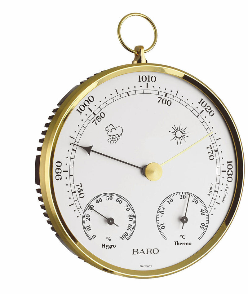 An aneroid barometer with gold casing on a white background
